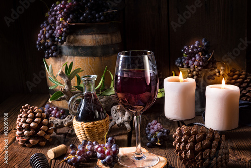 Red wine from a barrel with grapes and a glass of wine