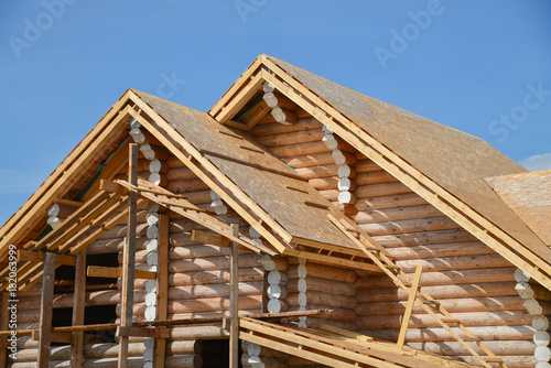 Structure of a new wooden house under construction on blue sky background