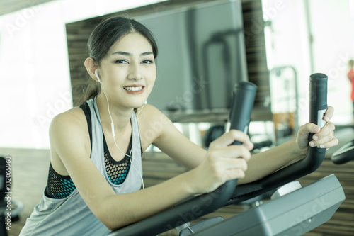 Portrait of Attractive Asian Woman on exercise bikes at a gym. Woman exercise Concept.