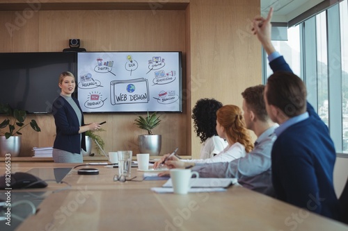 Businesswoman interacting with team during meeting in board room