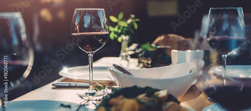 Billede på lærred Glass of wine at dining table