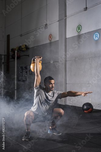 Muscular man workout with kettlebell
