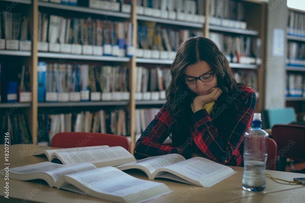 Girl reading book in library Girl reading book in library
