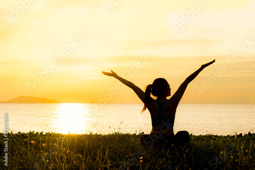 Meditation yoga lifestyle woman silhouette on the Sea sunset, relax vital. Healthy Concept