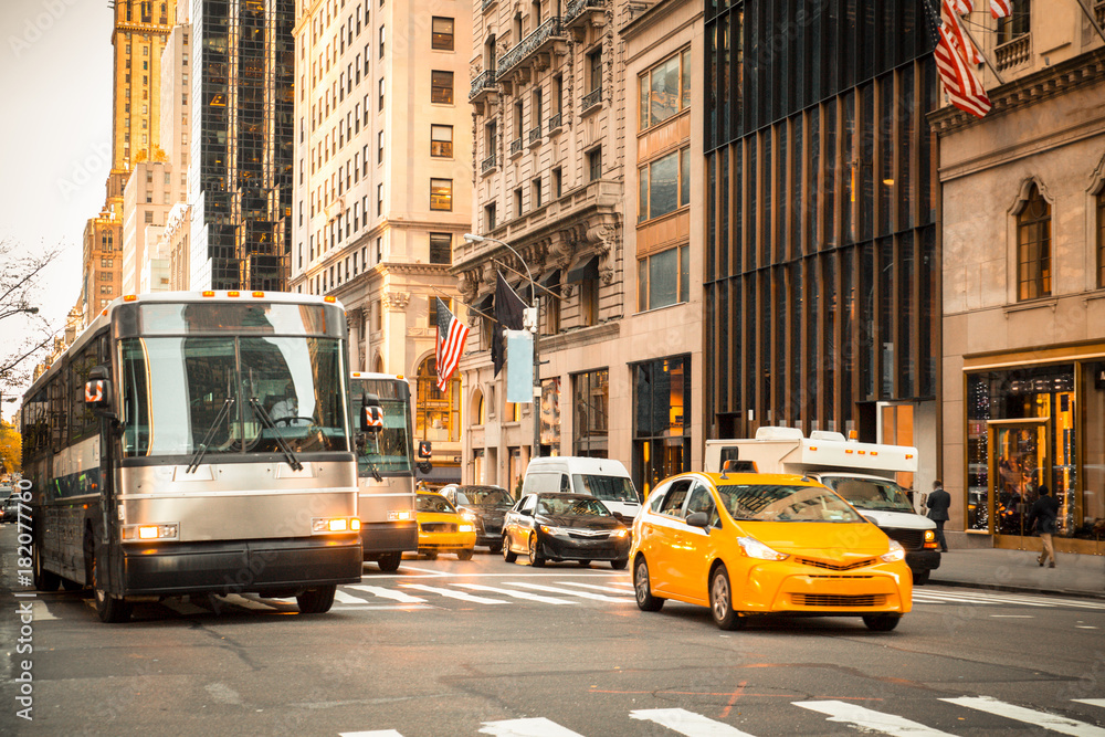 Obraz premium Ogólna scena uliczna w Nowym Jorku z autobusami taksówkowymi, samochodami na skrzyżowaniu i nierozpoznawalnymi ludźmi w typowej ekskluzywnej dzielnicy
