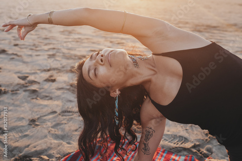 Beautiful woman doing yoga on beach photo