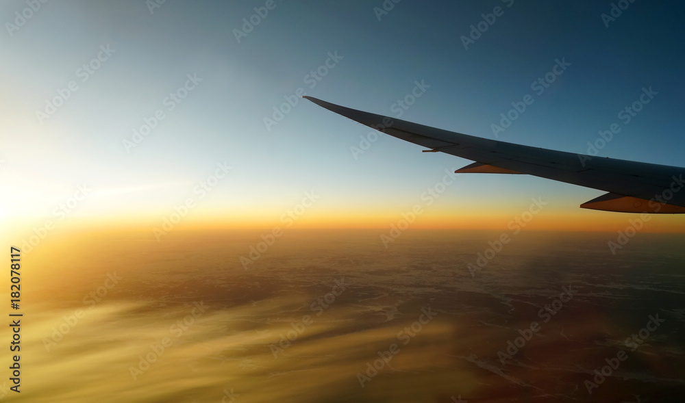 golden sunlight spreading on aerial cloud below airplane wing golden sunlight spreading on aerial cloud below airplane wing