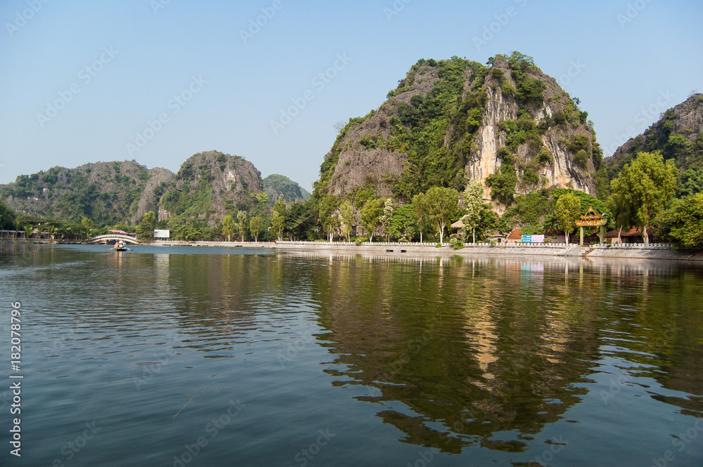 Houses and on a background of rocks on the river Ngo Dong. Ninh Binh Province, Ha Long Bay on land, Vietnam Houses and on a background of rocks on the river Ngo Dong. Ninh Binh Province, Ha Long Bay on land, Vietnam