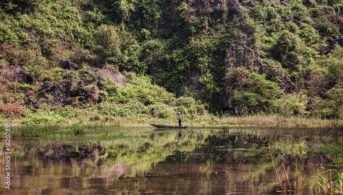 The boat is next to the rock. Ninh Binh Province, Ha Long Bay on land, Vietnam photo