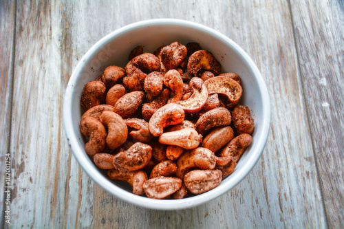 Roasted Cashews in bowl on wood.