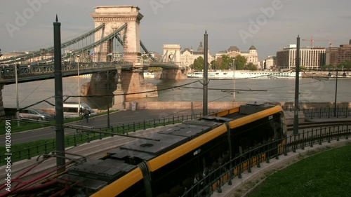 Static wide shot of modern tram passing in front of Chain Bridge in Budapest