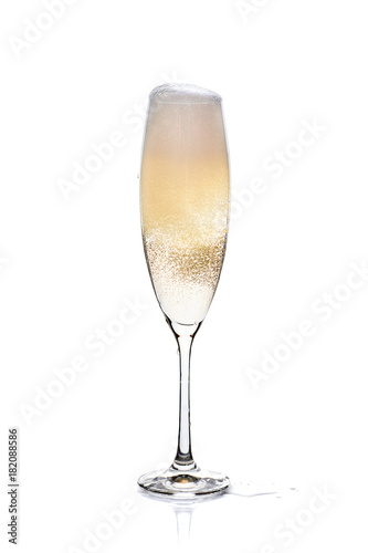 Glass of champagne with foam and bubbles on white