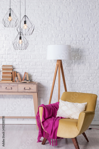 modern room concept with brcik wall desk chair and pink blanket