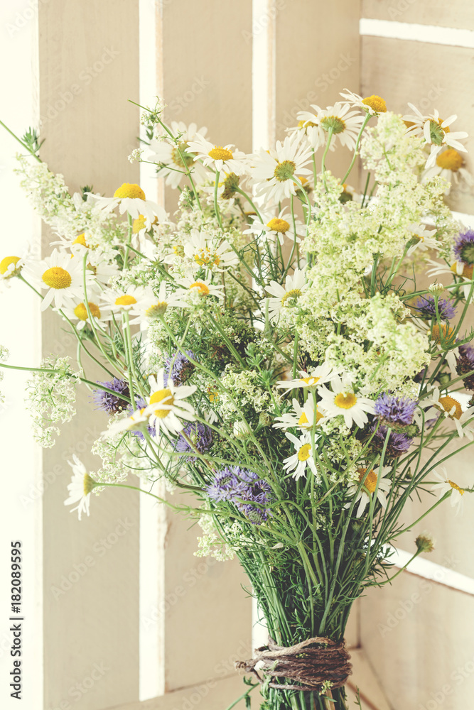 Beautiful spring bouquet with camomile in white rustic box, close up