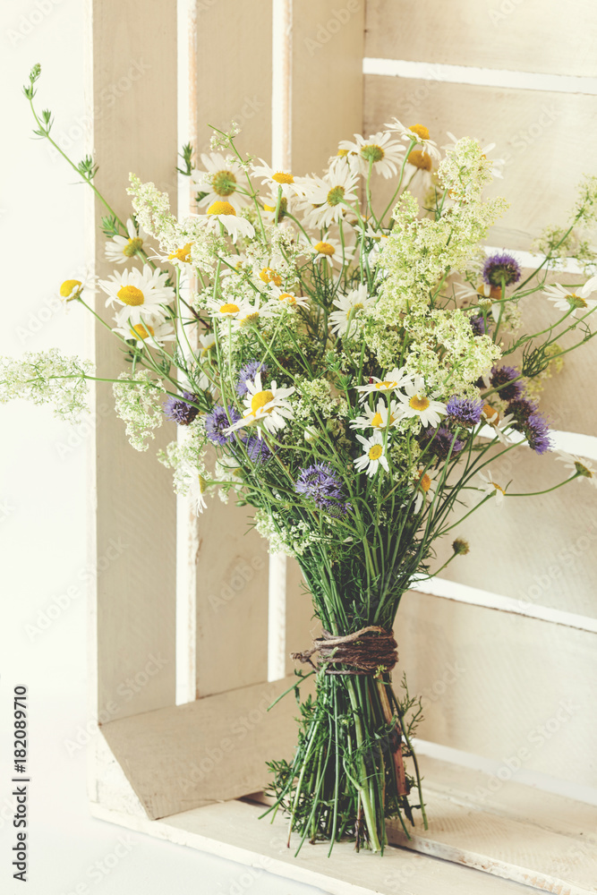 Beautiful spring bouquet with camomile in white rustic box