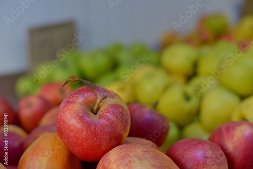 Tasty fresh red apples at grocery store.Buy & eat natural vitamin food.Farmer market department in food shop.Box of fruits on sale in fridge.Ripe red apples & oranges at food aisle in food department photo