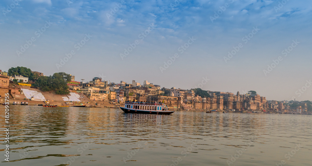 A view from River Ganges of Old Historical Varanasi city with weathered buildings at the time of Sunrise