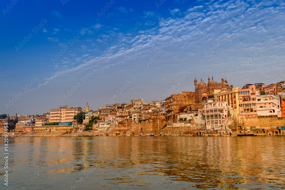 A view from River Ganges of Old Historical Varanasi city with weathered buildings at the time of Sunrise