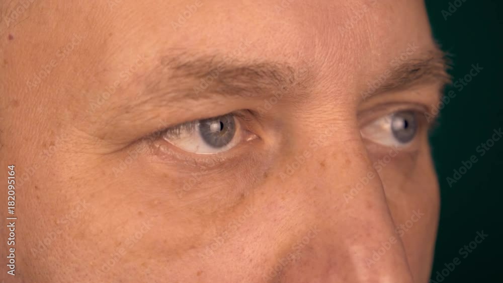 A fixed view of a man from a close distance. Male eyes look at the same point. Half-turned portrate male face extreme close up. A fixed view of a man from a close distance. Male eyes look at the same point. Half-turned portrate male face extreme close up.