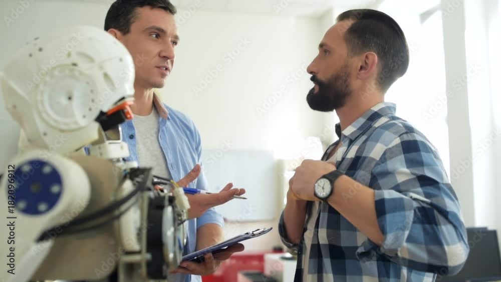 Perfect service. Close up of handsome skilled engineer writing down significant information while talking with a client