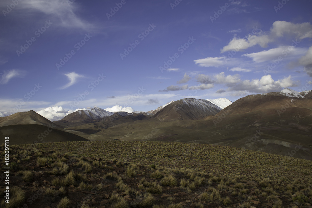 Fototapeta premium A Wide Angle Landscape shot of the beautiful mountains in the Altiplano of Bolivia, with bright clear skies and colorful desert below