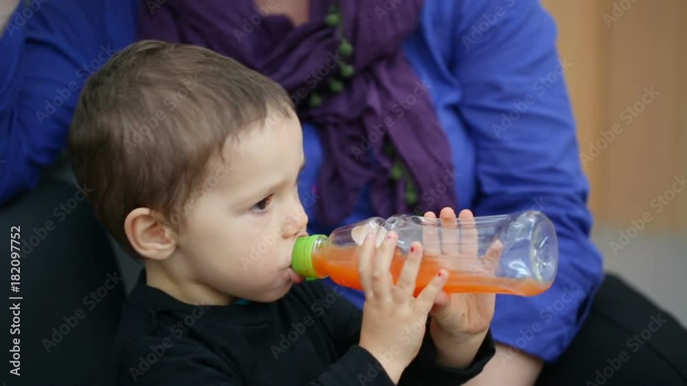 Woman sitting with her son in the hospital while he is drinking juice
Woman sitting with her son in the hospital while he is drinking juice