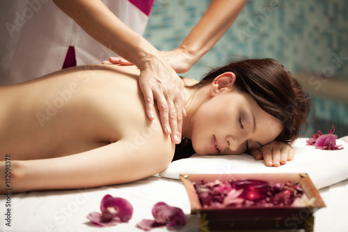 Spa salon: Beautiful Young Woman having Massage at her Back