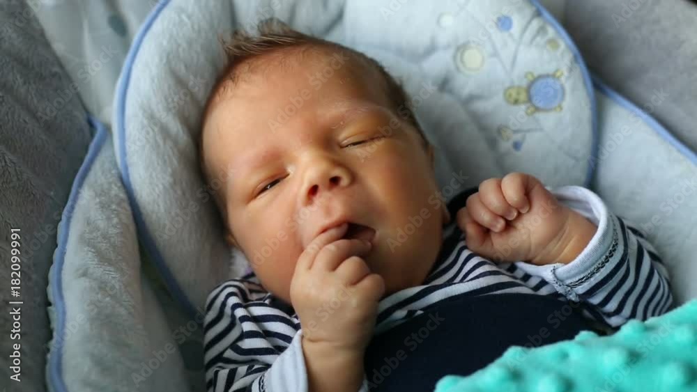 Adorable newborn baby lying in bed and eats hand because of hunger
Adorable newborn baby lying in bed and eats hand because of hunger