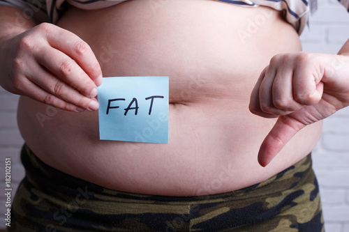 Overweight fat woman with a word Fat and thumb down. Negative emotions, motivation, weight losing concept.