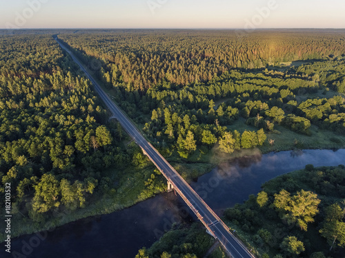 Aerial view over Merkys river valley, near Merkine town, Lithuania. During sunny summer season, surrounded by pine tree forest. photo