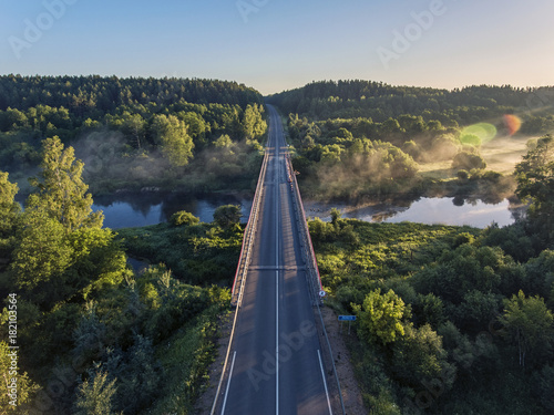 Aerial view over Merkys river valley, near Merkine town, Lithuania. During sunny summer season, surrounded by pine tree forest. photo