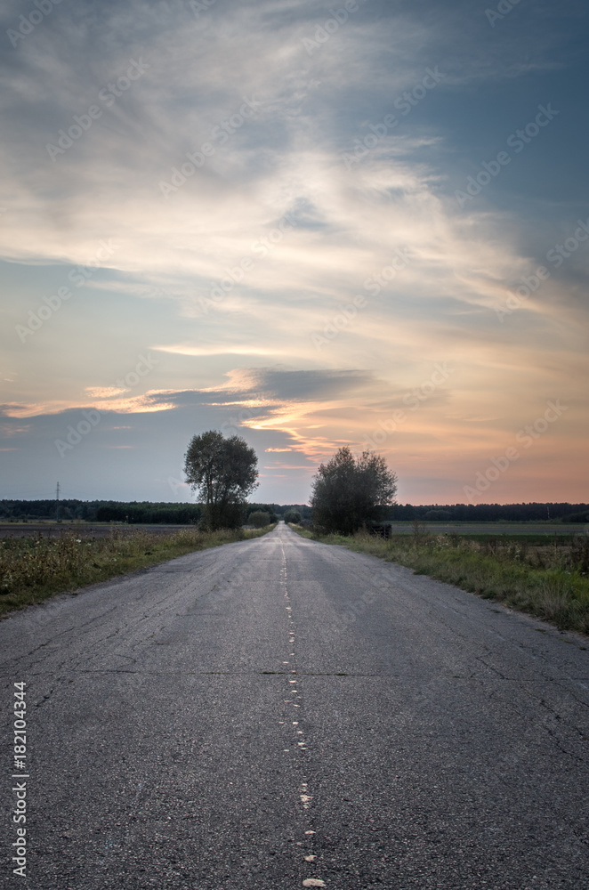 Empty asphalt country road during sunset