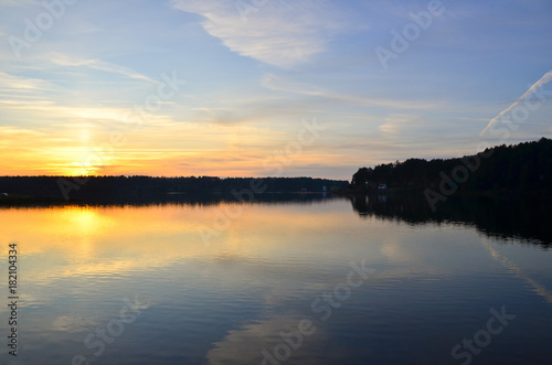 Beautiful orange sunset over the lake with sky reflected in the water