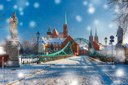 Tumski Bridge and Island with Cathedral of St. John and church of the Holy Cross and St. Bartholomew in the snowy overcast winter day in Wroclaw, Poland