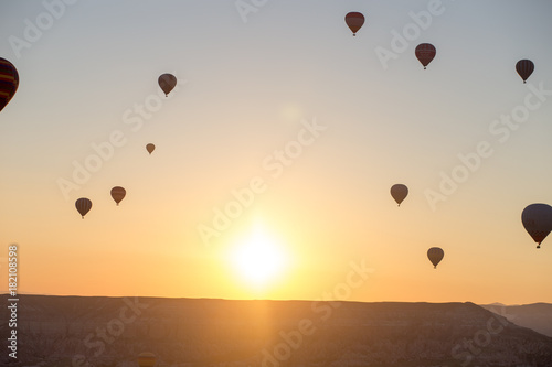 Hot air balloons over mountain landscape in Cappadocia, Goreme National Park, Turkey.