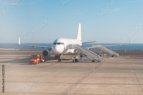airplane standing on runway with stairs ready for boarding