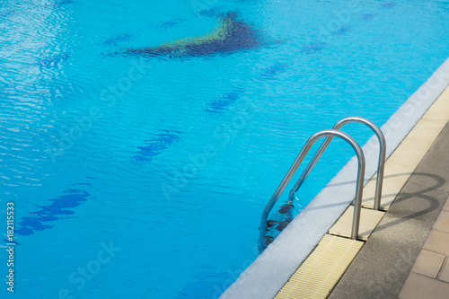Grab bars ladder in the blue swimming pool. Concept Healthy exercise.
