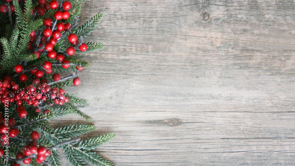 Holiday Evergreen Branches and Berries Over Rustic Wood Background - obrazy, fototapety, plakaty 