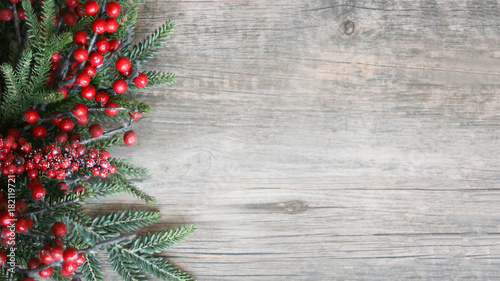 Holiday Evergreen Branches and Berries Over Rustic Wood Background photo
