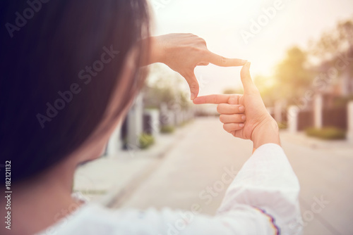 Close up of woman hands making frame gesture with sunlight outdoor, Future planning concept. photo