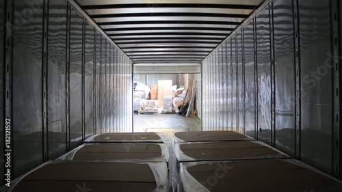 Worker on the loader unload semi-trailer. Shooting from inside of the trailer. Timelapse.