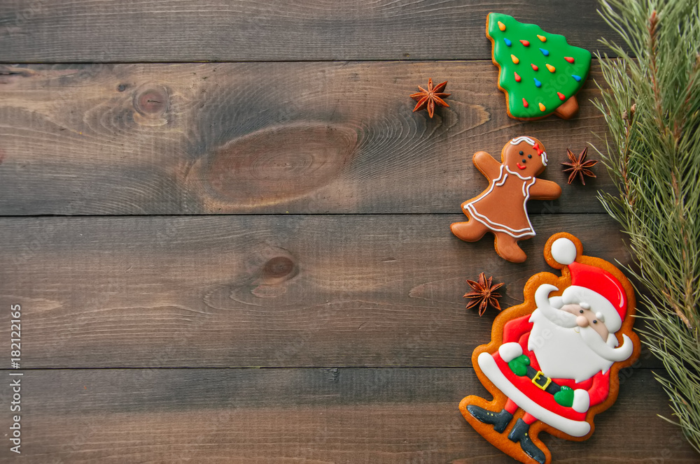 Christmas background. Different shapes of gingerbread cookies and decorations on a wooden backdrop. Copy space and top view.