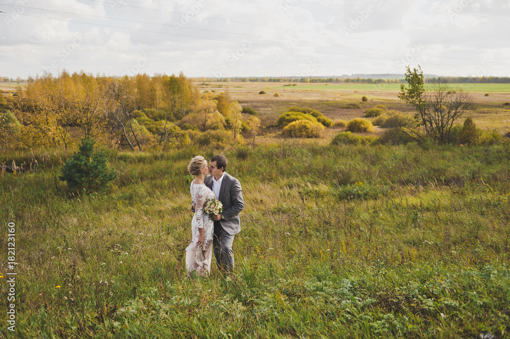 Portrait of lovers newlyweds on the background of endless fields