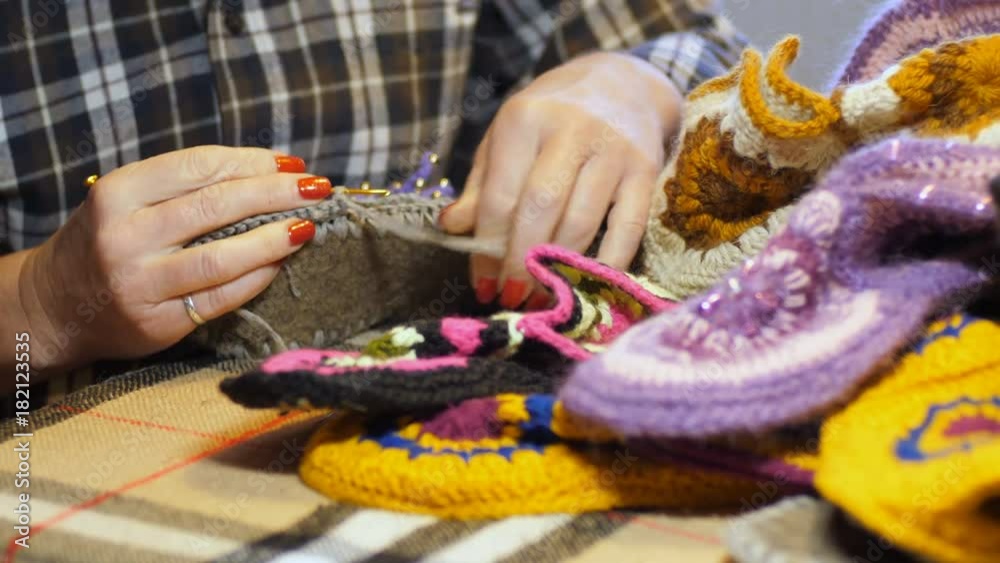 Woman knits crocheted blanks for making soft home slippers Woman knits crocheted blanks for making soft home slippers