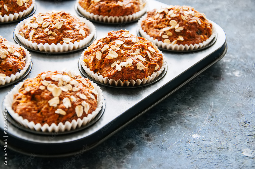 Carrot cake muffins with nuts, raisins and oats on a blue stone background. Close up with copy space. Carrot cake muffins with nuts, raisins and oats on a blue stone background. Close up with copy space.