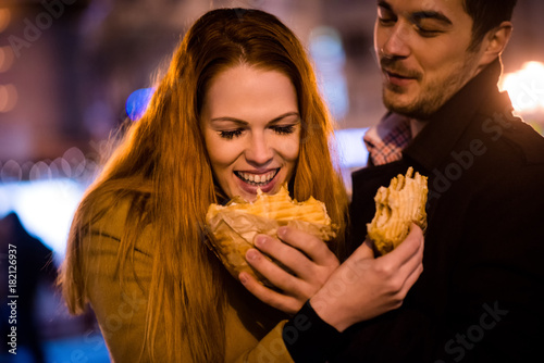 Couple having fun - eating together in street