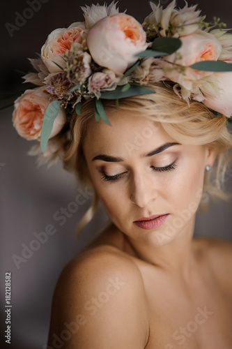Romantic topless look of attractive blonde woman in a floral wreath with closed eyes