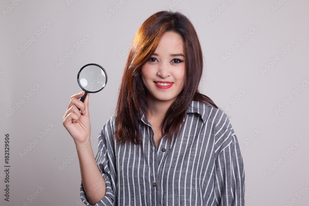 Young Asian woman with a magnifying glass. Young Asian woman with a magnifying glass.