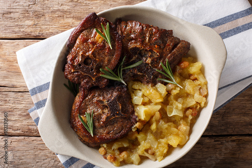 Roasted lamb steak and spicy apple chutney close-up in a bowl. Horizontal top view