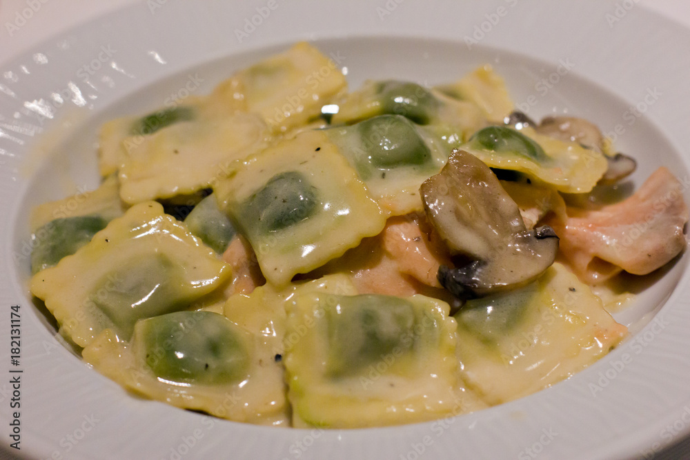 Ravioli with salmon and mushrooms on a white plate Ravioli with salmon and mushrooms on a white plate
